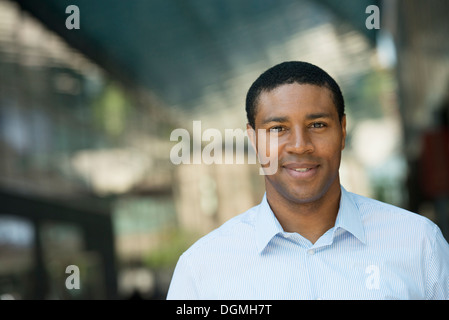 Geschäftsleute unterwegs. Ein lächelnder Mann in einem offenen necked Hemd. Stockfoto