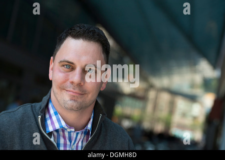 Geschäftsleute unterwegs. Ein Mann in einem offenen necked Hemd und Jacke. Stockfoto