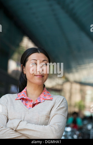 Geschäftsleute unterwegs. Eine Frau in einem rosa Hemd und Beige Pullover. Stockfoto