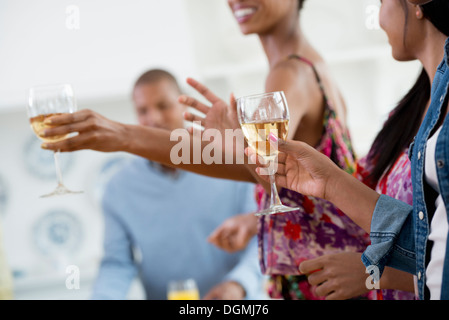 Ein informelles Büro-Ereignis. Menschen, die Ausgabe von Platten von Lebensmitteln über ein Buffet-Tisch. Stockfoto