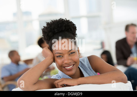 Gruppe von Menschen. Eine junge Frau lächelt breit. Stockfoto