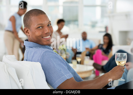 Büro. Ein junger Mann mit einem Glas Wein. Stockfoto