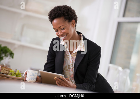 Business-Leute. Eine Frau in einer schwarzen Jacke mit einem digitalen Tablet. Stockfoto