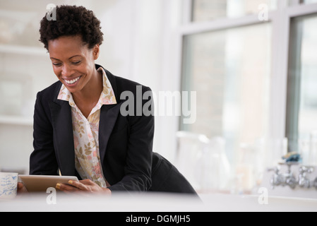 Business-Leute. Eine Frau in einer schwarzen Jacke mit einem digitalen Tablet. Stockfoto