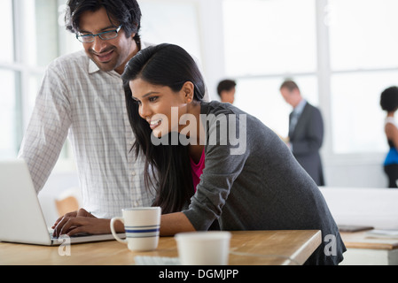 Büro. Ein Mann und eine Frau mit einem Laptopcomputer. Stockfoto