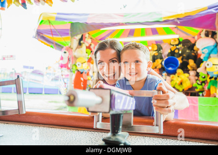 USA, Utah, Salt Lake City, Mutter und Sohn (4-5) spielt mit Wasserpistole im Vergnügungspark Stockfoto