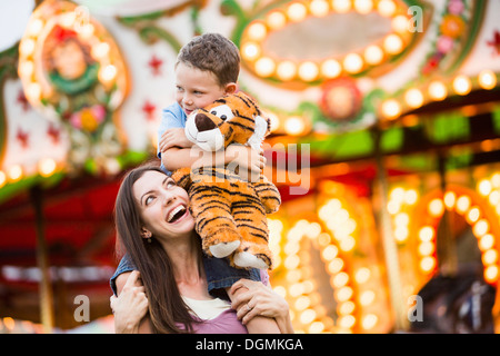 USA, Utah, Salt Lake City, Mutter, ihr Sohn (4-5) Huckepack Fahrt im Vergnügungspark Stockfoto