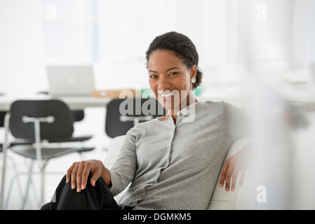 Geschäft. Eine Frau sitzt auf dem Sofa entspannt suchen. Stockfoto