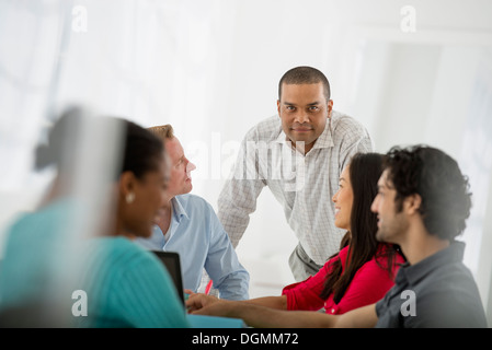 Eine Multi ethnische Gruppe von Menschen rund um einen Tisch, Männer und Frauen. Teamarbeit. Treffen. Stockfoto