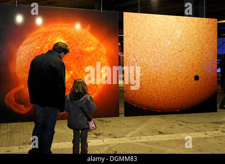 Vater Explaing ein großes Foto von der glühenden Sonne zu seiner jungen Tochter: Ausstellung Wunder des Sonnensystems Stockfoto