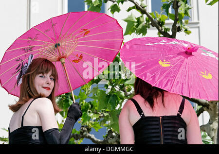 Zwei Jugendliche in schwarzer Kleidung mit Japanpapier Sonnenschirme, einem Lächeln frech, Cosplayer, Japantag Japan Tag, Düsseldorf Stockfoto