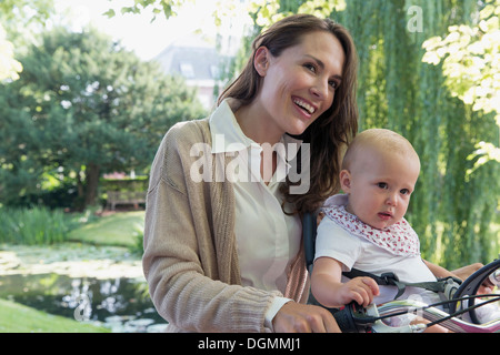 Niederlande, Südholland, Oud-Beijerland, Mutter mit Tochter Baby (12-17 Monate) auf Fahrrad Stockfoto