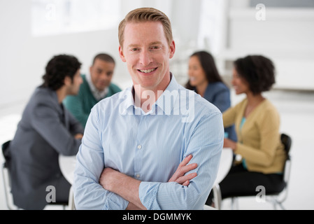 Business-Meeting. Eine Gruppe an einem Tisch sitzen. Ein Mann selbstbewusst Lächeln. Stockfoto