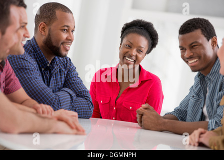 Büro. Eine Gruppe von vier Personen, zwei Männer und zwei Frauen sitzen reden. Stockfoto