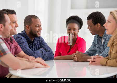 Büro. Eine Gruppe von vier Personen, zwei Männer und zwei Frauen sitzen reden. Stockfoto