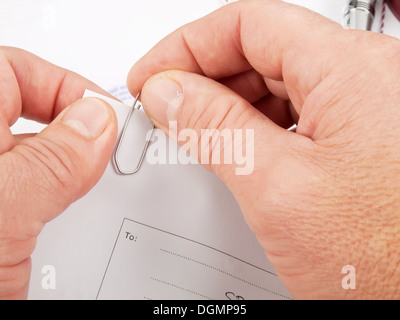 Offizier zusammenführen Papiere mit Büroklammer im Büro Stockfoto