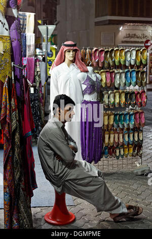 Verkäufer sitzen gelangweilt vor seinem Geschäft, alte Souk Deira, Vereinigte Arabische Emirate, Nahost, Asien Stockfoto