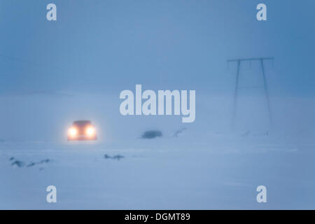 Jeep fahren in der Dämmerung, Dämmerung, an einem verschneiten Highland Straße, Hrauneyjar, Island, Europa Stockfoto