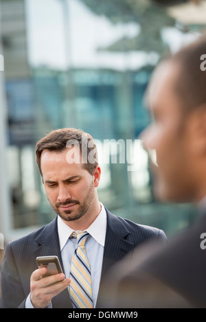 Stadt. Ein Mann im Anzug seine Nachrichten auf seinem Smartphone. Stockfoto