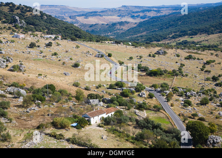 Von Grazalema Dorf gesehen Straße führt durch die Landschaft des Naturparks Sierra de Grazalema, Provinz Cadiz, Spanien Stockfoto