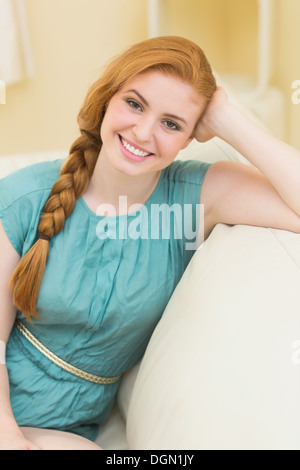 Rothaarige sitzen auf der Couch, Blick in die Kamera Lächeln Stockfoto