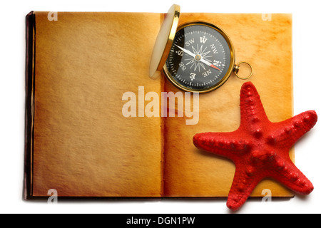 Kompass und rote Seastar auf offenes Buch Stockfoto