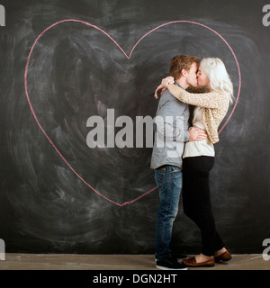 Studio-Porträt des jungen Paares umarmen vor Tafel Stockfoto