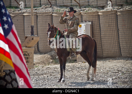 KHOWST Provinz, Afghanistan – US Army 1st Lt. Jeremy A. Woodard, ein Ingenieur mit 61. Kavallerie-Regiment, 1st Squadron, 4th Brigade Combat Team, 101st Airborne Division (Air Assault), begrüßt die amerikanische Flagge aus auf einem Pferd, während die großartig Stockfoto