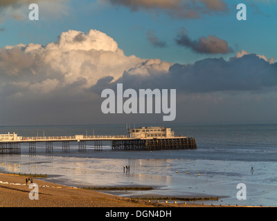 Abendlicht an der Westseite des Worthing Pier spiegelt sich in einer Muschel Meer mit starken Wolken am Horizont England Stockfoto