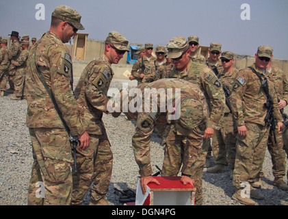 KHOWST Provinz, Afghanistan – A US Armee-Soldat mit 61. Kavallerie-Regiment, 1st Squadron, 4th Brigade Combat Team, 101st Airborne Division (Air Assault), ist durch seine Beine als seine Kollegen aufgehalten, die Soldaten Platz auf seine Stiefel, während einer Zeremonie Sporn am spornt Stockfoto