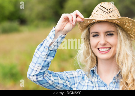 Hübsche junge Frau trägt einen Strohhut Stockfoto