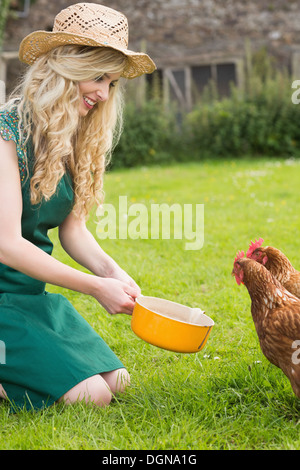 Junge Frau, die ihre Hühner füttern Stockfoto
