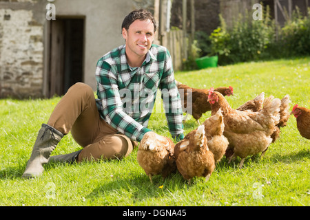 Junger Mann seine Kamera lächelt Hühner füttern Stockfoto