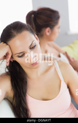 Verärgert Frau sitzt neben ihrer Freundin auf der couch Stockfoto