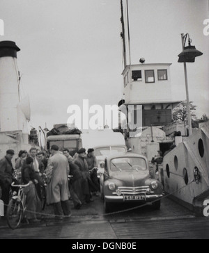 1950er Jahren Geschichtsbild von Passagieren, Radfahrer und Autos warten oder zum Aussteigen oder Aussteigen aus einem Flüsschen Fähre bereit. Stockfoto