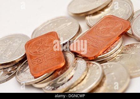 Ein Stapel von Silber Anlagemünzen mit zwei Kupferstangen an der Spitze Stockfoto