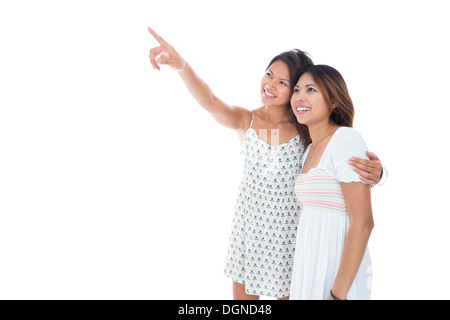 Süße asiatische Frauen zeigen etwas zu ihrer Schwester Stockfoto