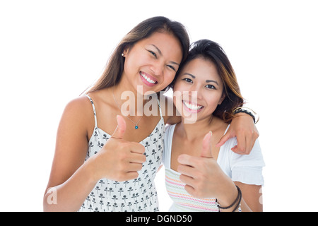 Zwei lächelnde asiatische Frauen geben Daumen hoch Stockfoto