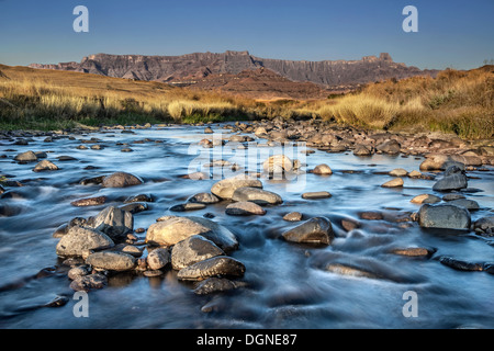 ein Fluss fließt vor der Drakensburg Stockfoto