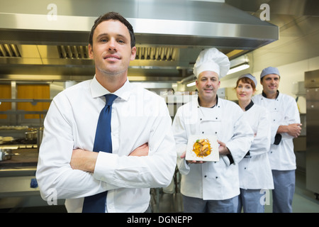 Junge Restaurantleiter posiert vor Küchenteam Stockfoto
