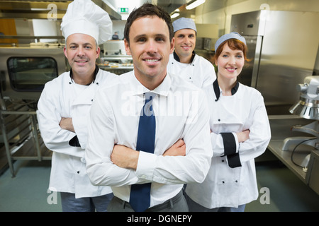 Restaurantleiter posiert vor Küchenteam Stockfoto