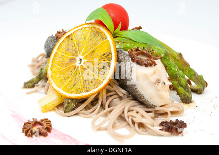 gebackener Fisch mit Spaghetti und Pilzen und Gemüse Stockfoto
