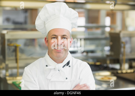 Reife Chefkoch posiert mit verschränkten Armen Stockfoto