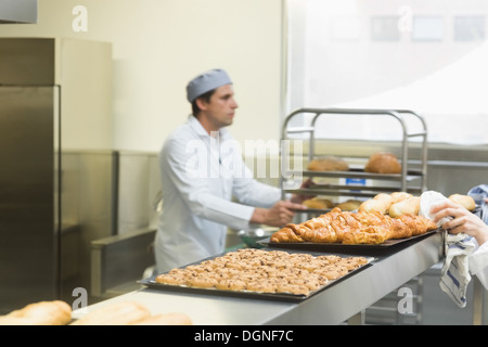 Junge männliche Bäcker arbeiten in einer Küche Stockfoto