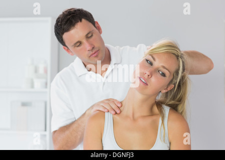 Gut aussehend Physiotherapeuten untersuchen Patienten Hals Stockfoto