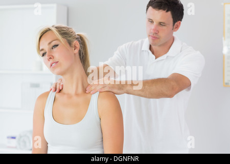 Gut aussehend Physiotherapeuten massieren Patienten Hals Stockfoto