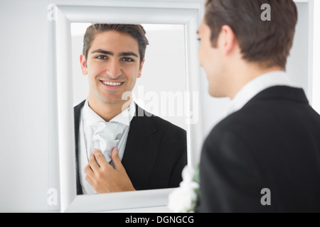 Fröhliche junge Bräutigam stehen vor einem Spiegel Stockfoto