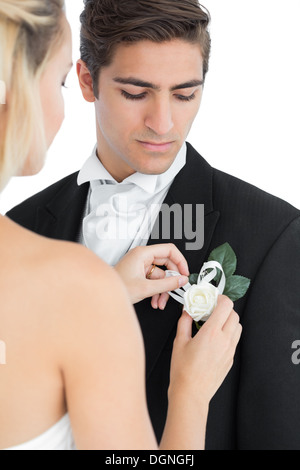 Junge Braut Anheften einer Blume auf ihre Ehemänner-Anzug Stockfoto