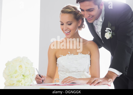 Glückliches junges Paar Unterzeichnung Hochzeit register Stockfoto