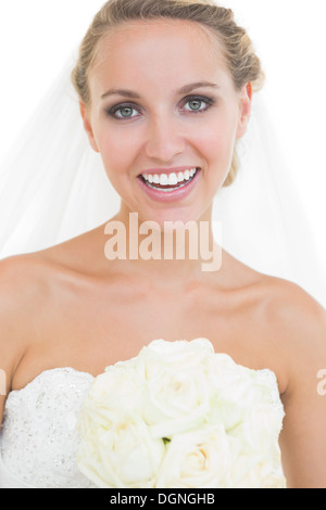 Fröhliche junge Braut posiert mit einem Blumenstrauß Stockfoto
